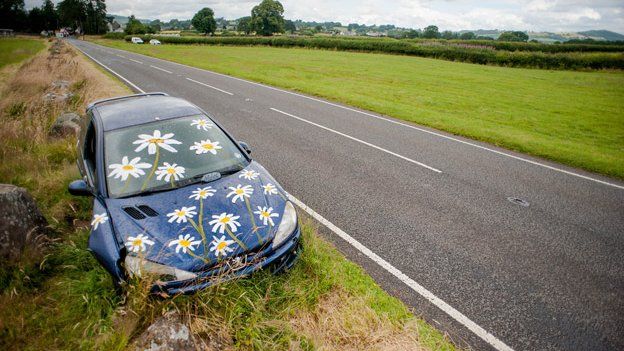 Abandoned Peugeot car painted with daisies