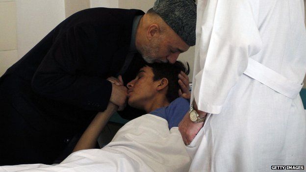 Hamid Karzai comforts injured soldier in Kabul. 2009