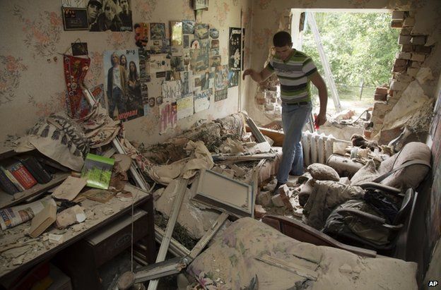 A man inspects his ruined flat in Marinka, Donetsk, 12 July