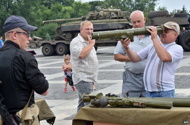 Ukrainian civilians in Kiev inspect weapons said to have been captured from the rebels, 12 July