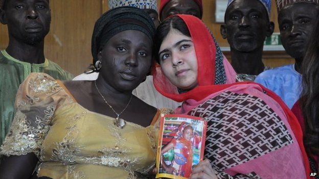 Pakistani activist Malala Yousafzai holds a picture of kidnapped schoolgirl Sarah Samwell with her mother Rebecca, during a visit to Abuja, Nigeria, 13 July 2014