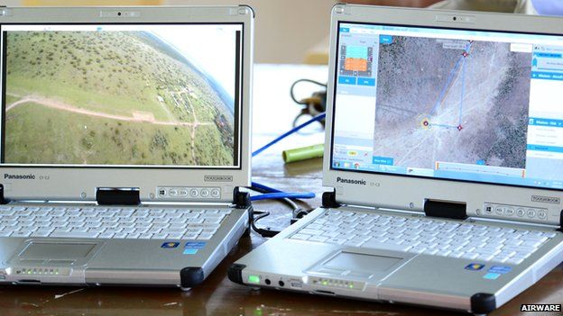 laptops showing aerial map and view from drone