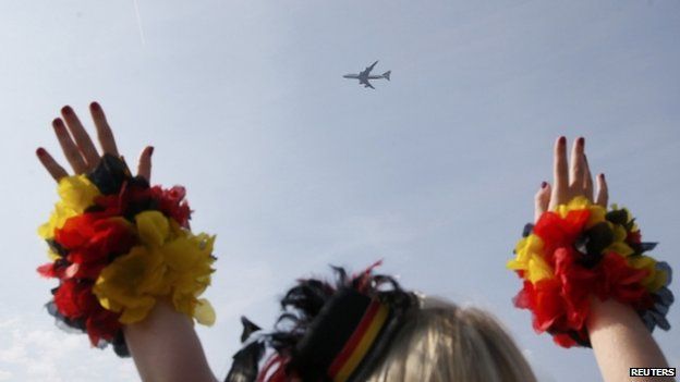 Fans cheer as the plane carrying the German national soccer team flies over the "fan mile" public viewing zone before landing at Tegel airport (14 July 2014)