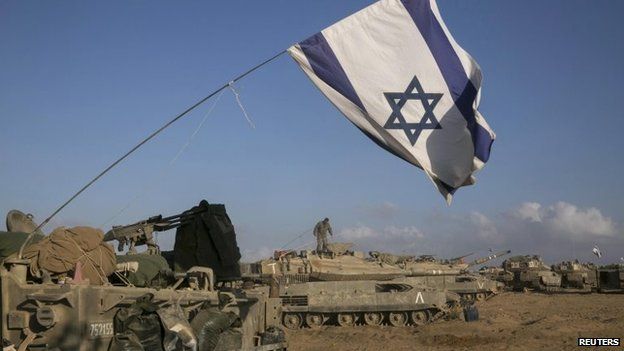 Israeli tanks and armoured personnel carriers (APCs) are seen at a staging area outside the central Gaza Strip July 15, 2014.