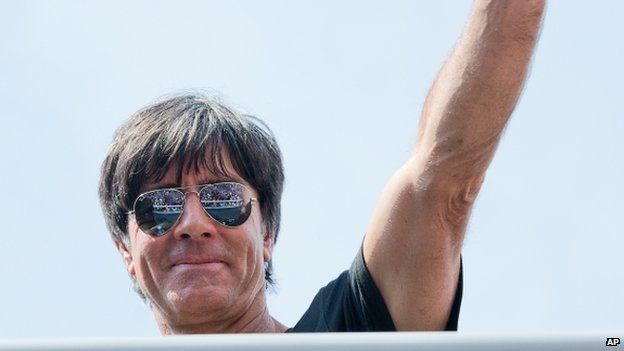 German national soccer coach Joachim Loew waves to fans after the arrival of the German soccer squad in Berlin