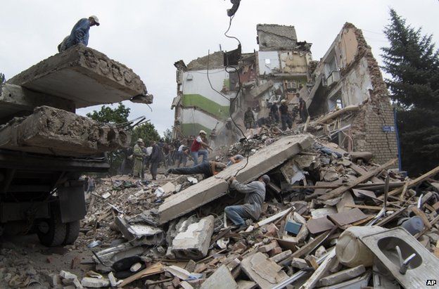 Rubble is cleared in Snizhne, eastern Ukraine, after the air strike, 15 July