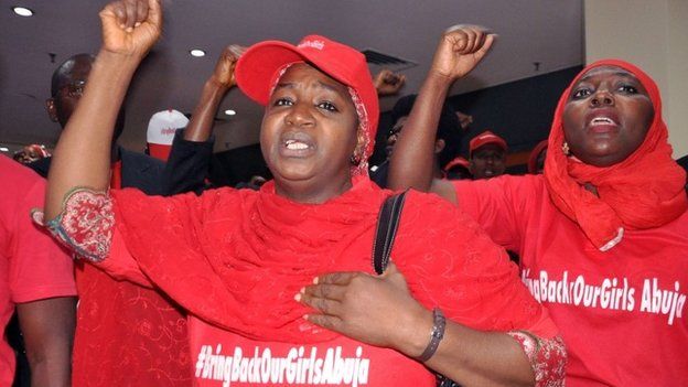 Women wearing t-shirts reading #Bringbackourgirls chant slogans in Abuja on 14 July 2014