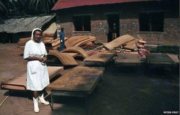 A nun standing beside beds in Yambuku, 1976
