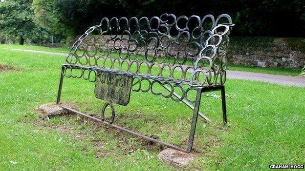Situated overlooking the village green and duck pond, the bench is constructed largely of horseshoes.
