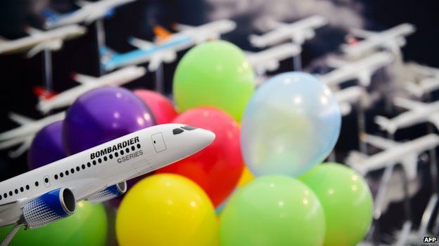 A model of a Bombardier C-Series jet is pictured among promotional balloons following a press conference at the Farnborough Airshow