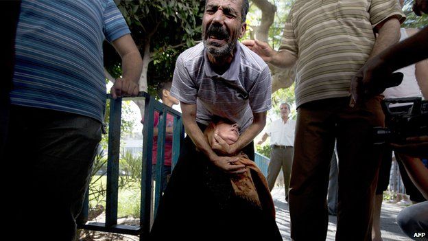 Palestinian relatives of the four boys killed in Israeli bombardment, all from the Bakr family, cry at the morgue of the hospital in Gaza City (16 July 2014)