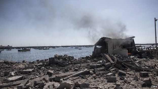 Palestinian children killed by Israeli naval bombardment in Gaza port: Smoke rises from a shed in the port of Gaza City where five young boys were killed by an Israeli naval bombardment (16 July 2014)