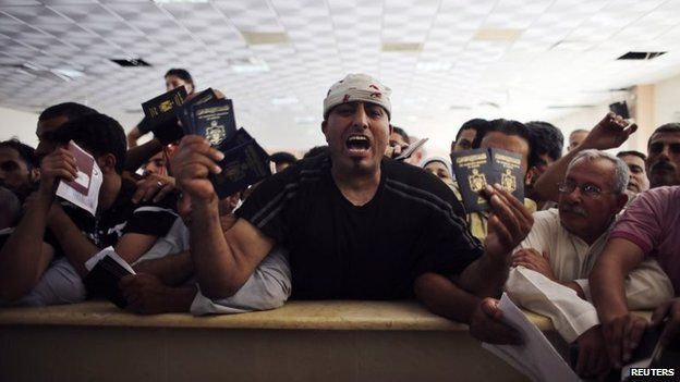 A man holds up passports at the Rafah border crossing between Gaza and Egypt (16 July 2014)