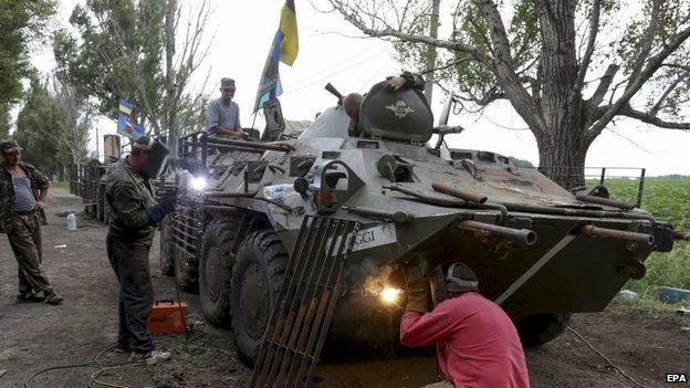Ukrainian soldiers modifying their Armoured Personnel Carrier (APC) near Izyum, Ukraine, 13 July 2014