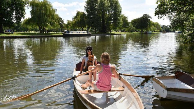 Cara Hanley (left) and Clemmie Stubbs (right) take their dog Stanley out for a boat trip on the river in Stratford-upon-Avon