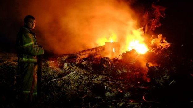 A firefighter stands as flames burst amongst the wreckages of the Malaysian airliner carrying 298 people from Amsterdam to Kuala Lumpur after it crashed, near the town of Shaktarsk, in rebel-held east Ukraine, on 17 July 2014