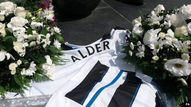 Flowers and football shirts outside St James Park