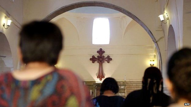 Iraqi Christians pray at a church outside the city of Mosul after fleeing violence - 1 July 2014