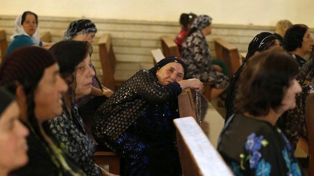 Iraqi women pray at a church outside the northern city of Mosul - 1 July 2014