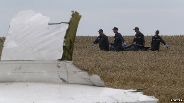 Members of the Ukrainian Emergency Ministry carry a body at the crash site of Malaysia Airlines Flight MH17