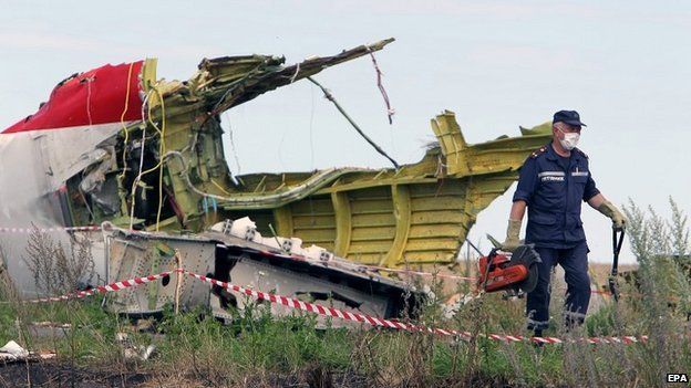 A rescue worker inspects the main crash site of the Boeing 777 in Grabove - 20 July 2014
