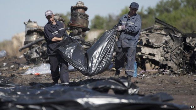 Ukrainian Emergency workers carry a victim's body in a bag at the crash site of Malaysia Airlines. Photo: 21 July 2014