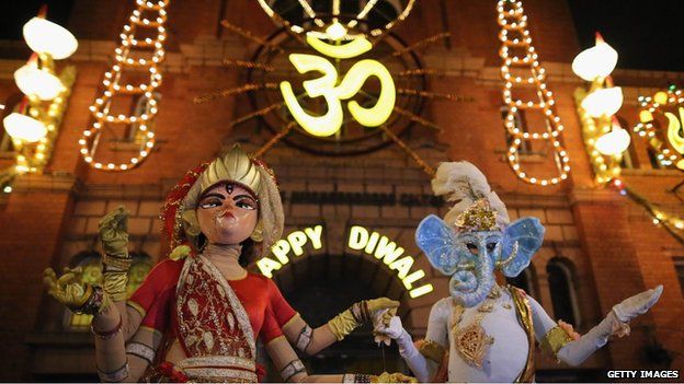 People dressed as the gods Lord Ganesha and Goddess Lakshmi walk through the streets during the Hindu festival of Diwali on November 13, 2012 in Leicester.