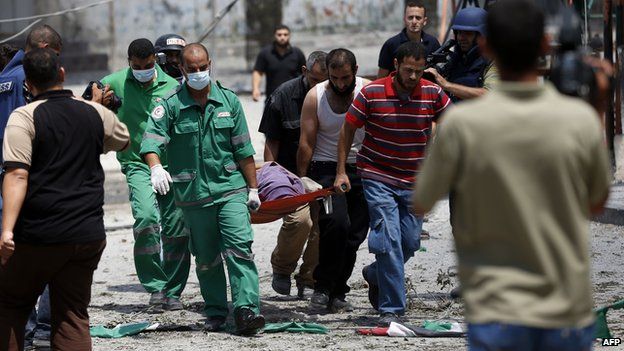 The body of a Palestinian killed in Shejaiya is carried away (20 July 2014)