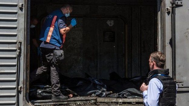 Dutch investigators and OSCE monitors examine the bodies in Torez. Photo: 21 July 2014