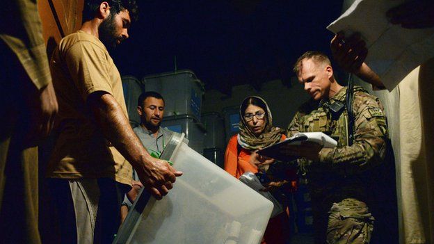 A NATO soldier in Jalalabad takes note of a ballot box for delivery to Kabul for a complete audit of all votes
