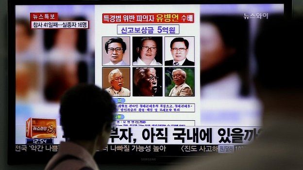 A woman looks at a 'wanted' poster for Yoo Byung-eun, shown on a South Korean TV news channel - 26 May 2014