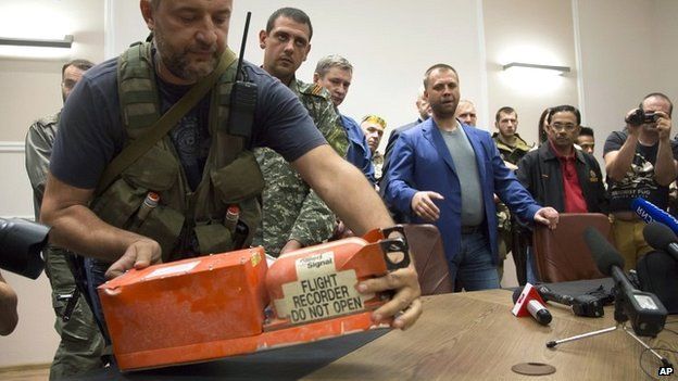 A rebel places a black box from flight MH17 on a table at a meeting to hand two data recorders over to Malaysian officials in Donetsk - 22 July 2014