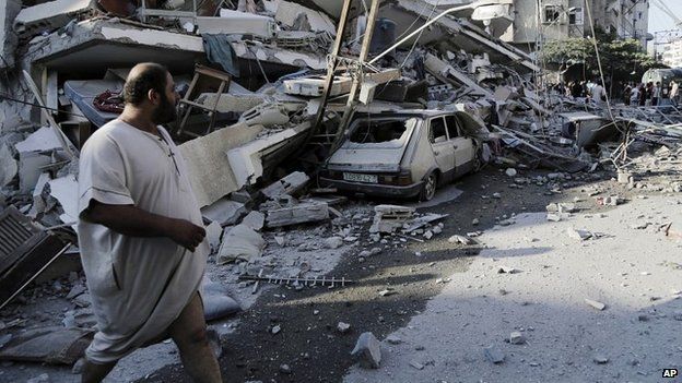 A man inspects the rubble of a four-storey building in Gaza City - 21 July 2014