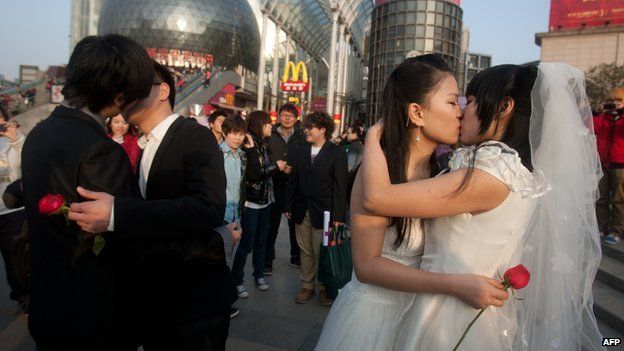 In a picture taken on 8 March, 2011 gay couples kiss during their ceremonial 'wedding' as they try to raise awareness of the issue of homosexual marriage, in Wuhan, in central China's Hubei province
