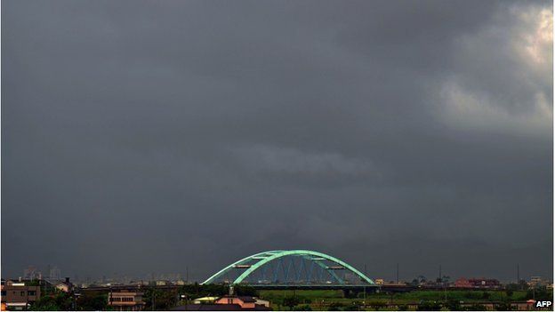 This general view shows dark clouds over a bridge above the Tungshan river in Ilan county as Typhoon Matmo approaches eastern Taiwan on 22 July 2014.