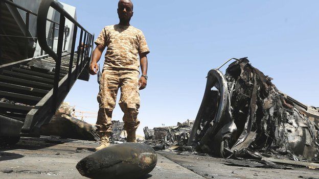 A militiamen at Tripoli airport in Libya amidst the debris of shelled planes - July 2014