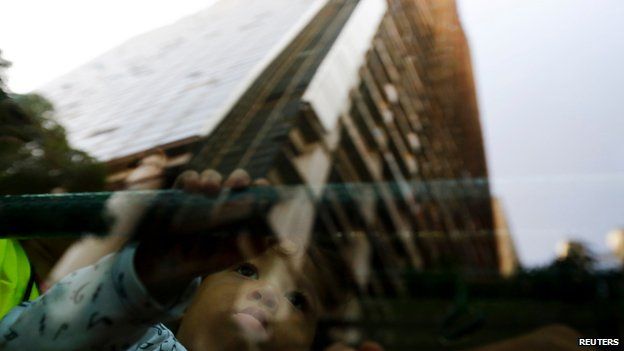 A child looks at a reflection of the Tower of David, 22 July 2014