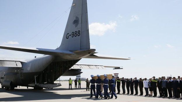 Honour guards carry a coffin of one of the victims of Malaysia Airlines MH17 at Kharkiv airport (23 July 2014)