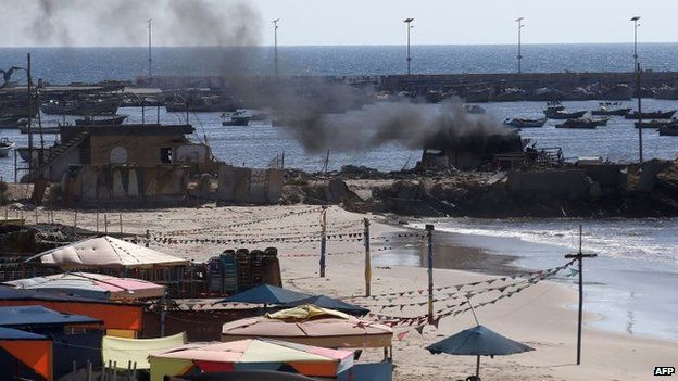 Smoke billows from a beach shack following an Israeli military strike on Gaza City, 16 July 2014