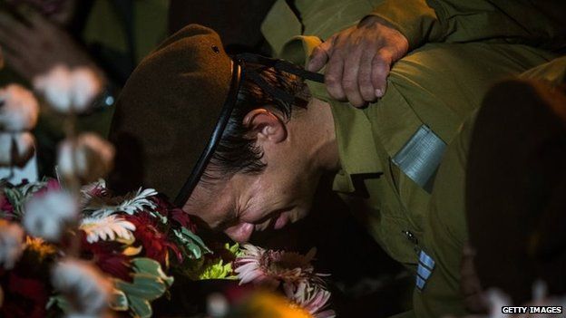 An Israeli soldier weeps over the casket of Private First Class Jordan Bensimon during his funeral in Ashkelon, Israel, 22 July 2014