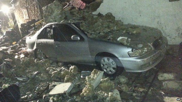 A vehicle is covered in rubble from the wreckage from a Taiwan domestic airline that crashed while attempting to land in typhoon weather on the island of Penghu