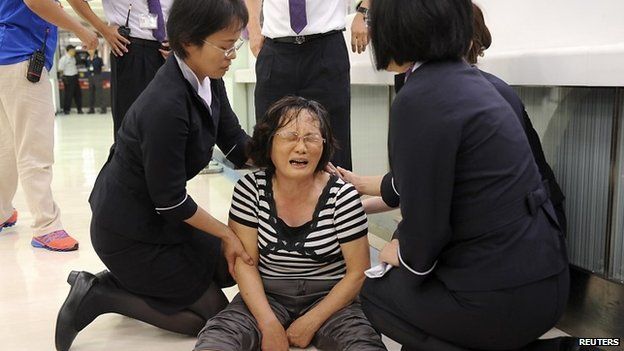 A relative of a passenger on board the crashed TransAsia Airways plane cries in Kaohsiung International Airport, southern Taiwan (23 July 2014)