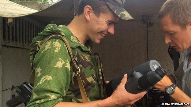 Ukrainian soldier holding a pair of binoculars