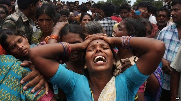 A relative of a victim cries at the site of a train that crashed into a school bus in Medak district in the southern Indian state of Telengana, Thursday, July 24, 2014.