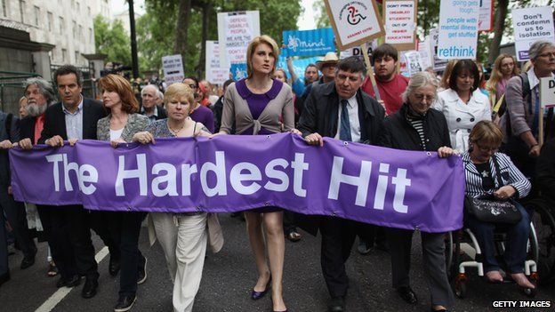 Campaigners carrying a banner saying "The Hardest Hit"