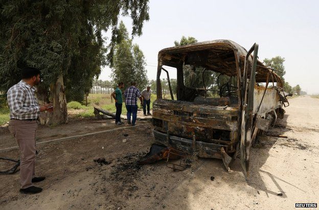 A charred bus at the spot where the ambush took place in Taji, Iraq, 24 July