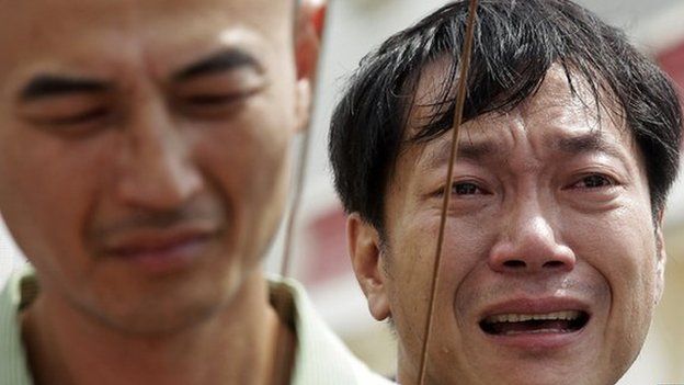 Relatives of passengers on board the crashed Transasia Airways plane cry on the Taiwan's offshore island Penghu, 24 July 2014.