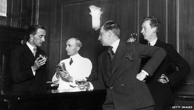 November 1927: Writers and brothers Osbert (1892 - 1969) and Sacheverell Sitwell (1897 - 1988) watch Martyn Roland of the Savoy Hotel and Harry Craddock the barman demonstrate how to shake a cocktail