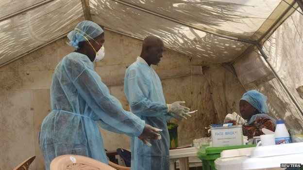 Health workers take blood samples for Ebola virus testing at a screening tent in the local government hospital in Kenema, Sierra Leone, on 30 June 2014.