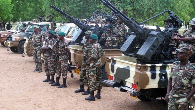 Cameroonian soldiers standing next to pick up trucks with mounted heavy artillery in Mora, northern Cameroon, on 17 June 2014
